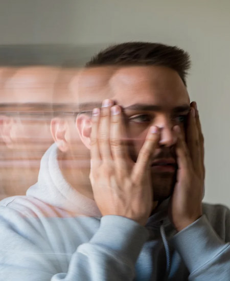 Мужчина держится за лицо руками